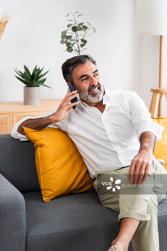 在家打电话的微笑男人图片素材