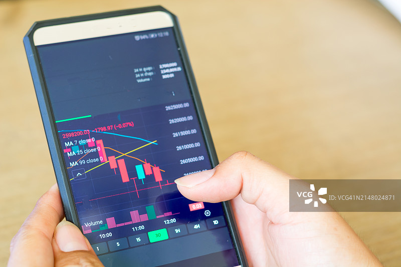 投资者在智能手机上分析金融加密股票交易市场图片素材
