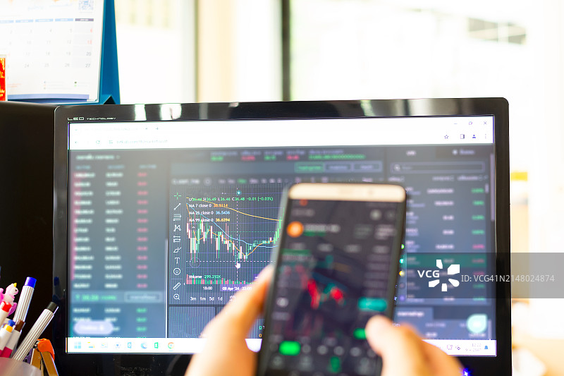 投资者在智能手机上分析金融加密股票交易市场图片素材
