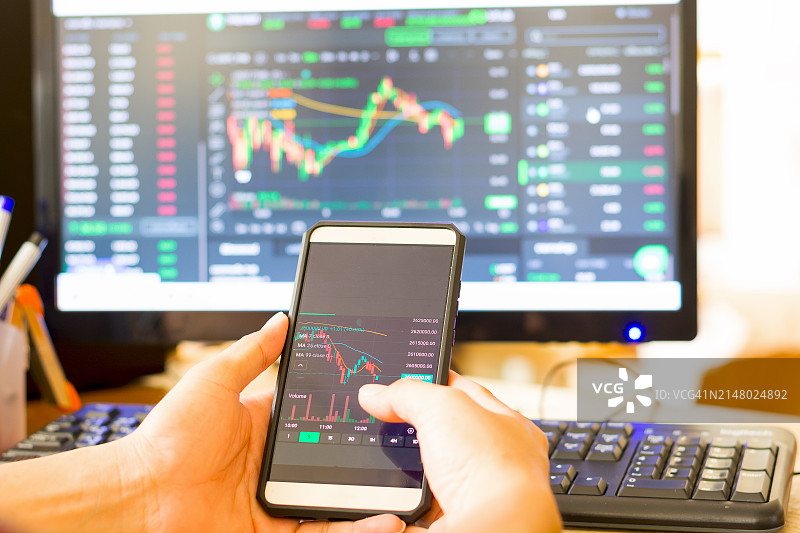 投资者在智能手机上分析金融加密股票交易市场图片素材