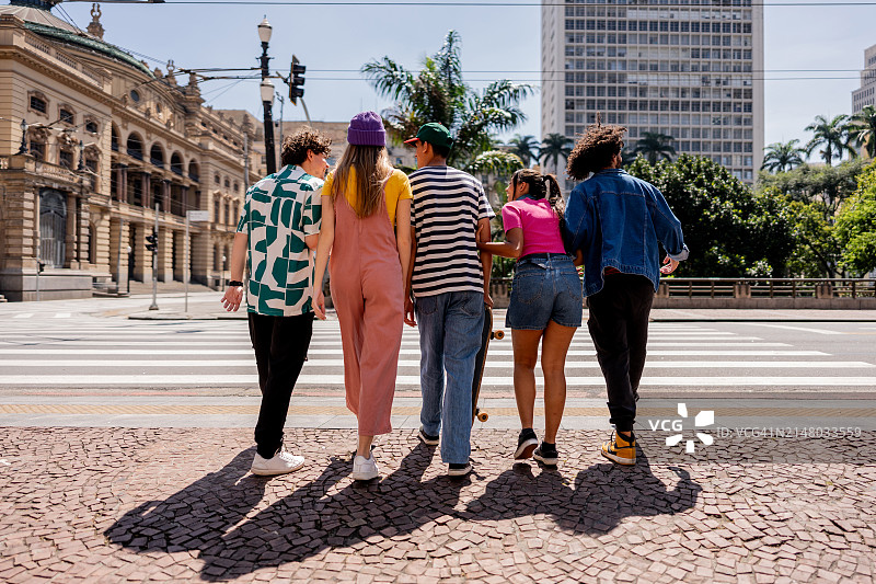 年轻的朋友们在人行横道过马路图片素材