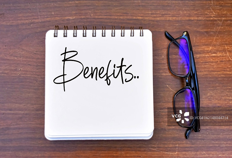 木桌上带有Benefit一词的记事本图片素材