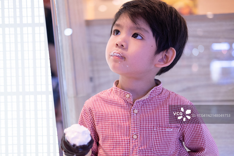 吃美味巧克力冰淇淋的亚洲小男孩图片素材
