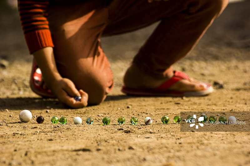 在土耳其，玩绿色和白色弹珠的人的下半身视角图片素材