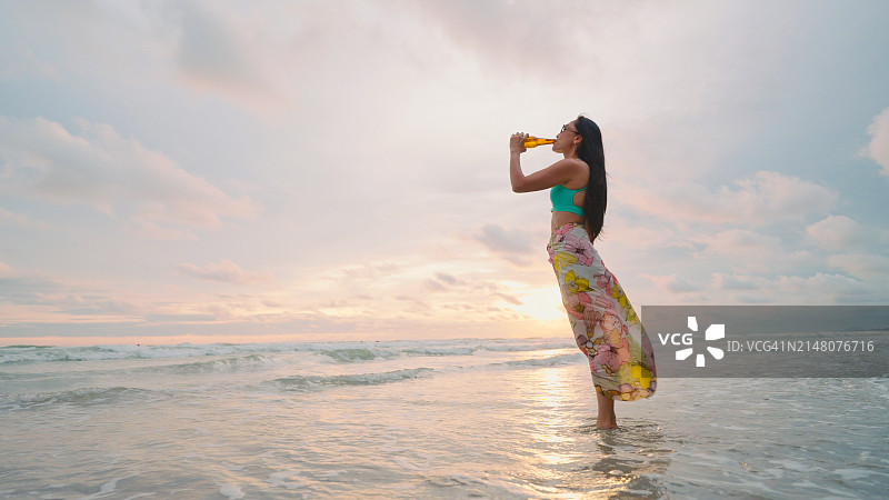 在海滩度假并饮酒的女游客图片素材