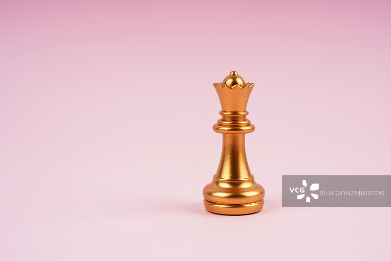 粉色背景上的金色国际象棋皇后图片素材