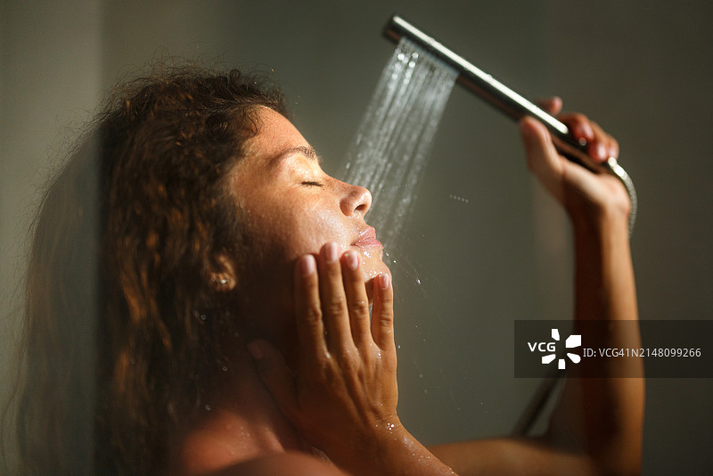 女人闭着眼睛享受淋浴图片素材