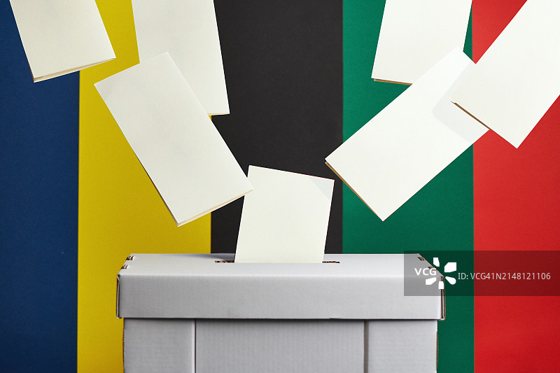 选票飞入纸板投票箱，彩色背景图片素材