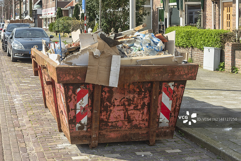 装满各种建筑废料的生锈的敞开式工业废料容器图片素材