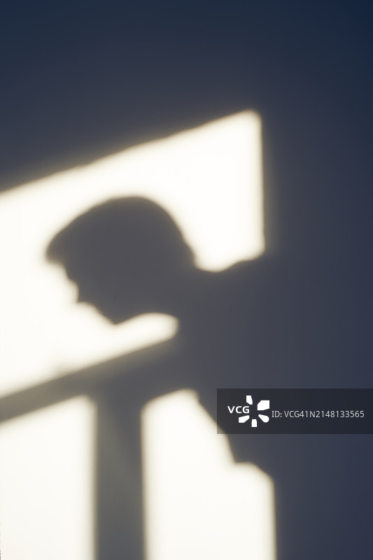 男人在窗框背景下的轮廓阴影图片素材