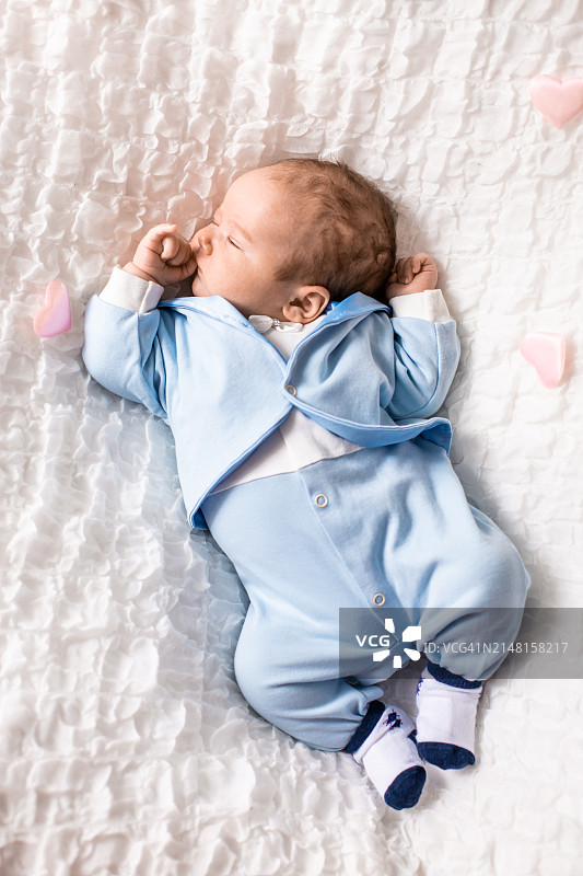 俯视角度拍摄的躺在床上男婴的照片图片素材