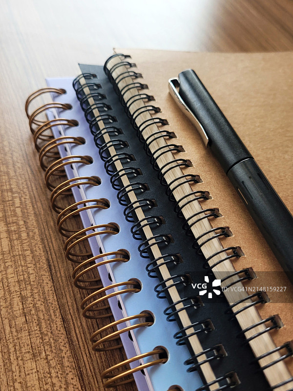 木桌上的螺旋笔记本特写图片素材