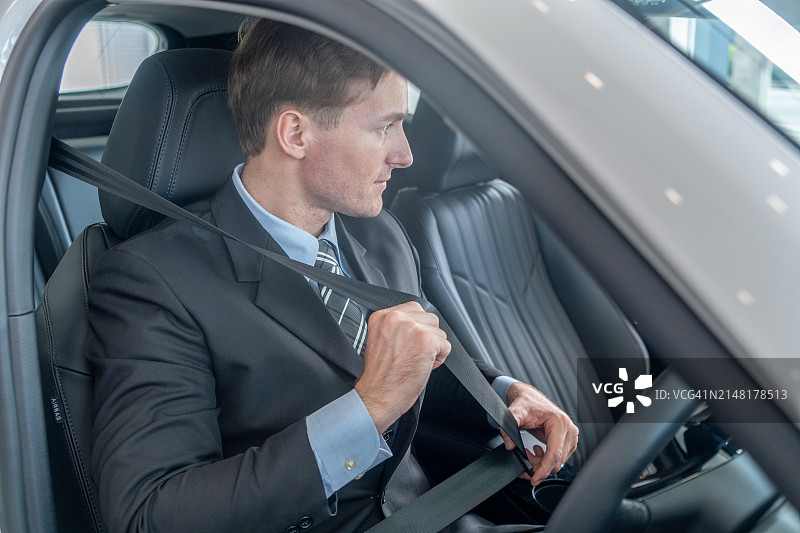 商人系好汽车安全带。图片素材