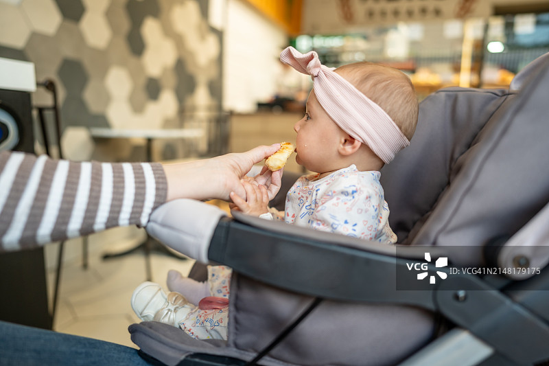 吃新鲜牛角包的女婴图片素材
