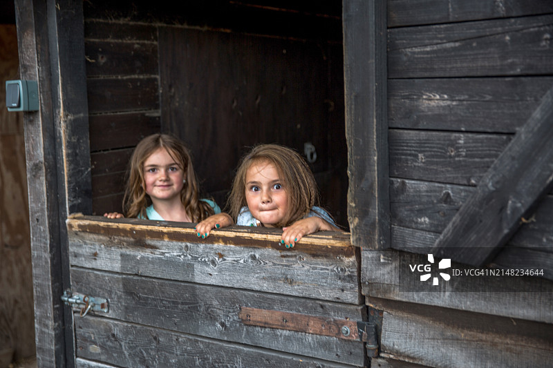 在谷仓门口的两位年轻女性亲戚图片素材