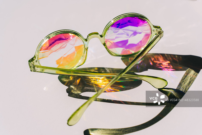 万花筒玻璃杯，阳光明媚的白色背景，彩色反射图片素材