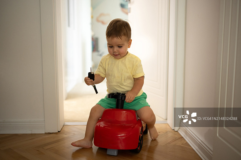 可爱的小男孩在家玩玩具车图片素材