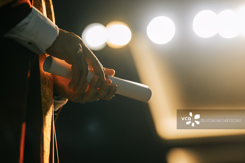 亚洲院长在礼堂舞台上拿着毕业证书的特写图片素材