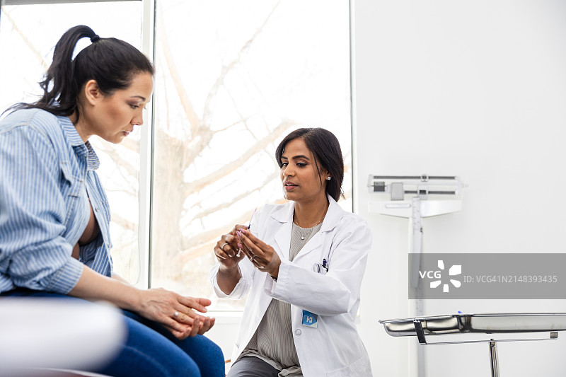 女医生向女病人讲解注射器使用方法图片素材