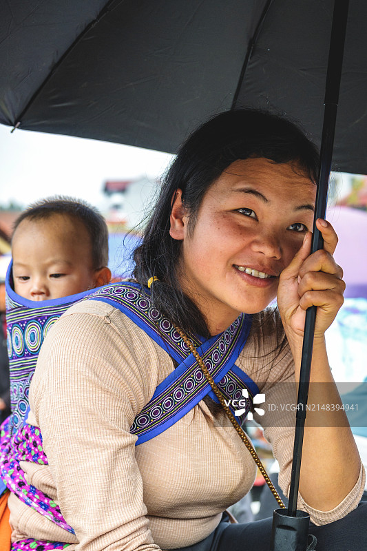 来自土著部落的年轻妇女在沙巴地区背着婴儿图片素材