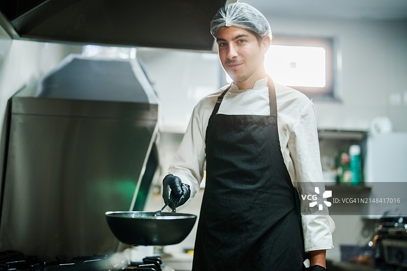 厨师手持平底锅对着镜头微笑图片素材