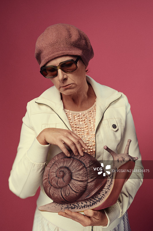 站在粉色背景前的戴墨镜女人，波兰图片素材