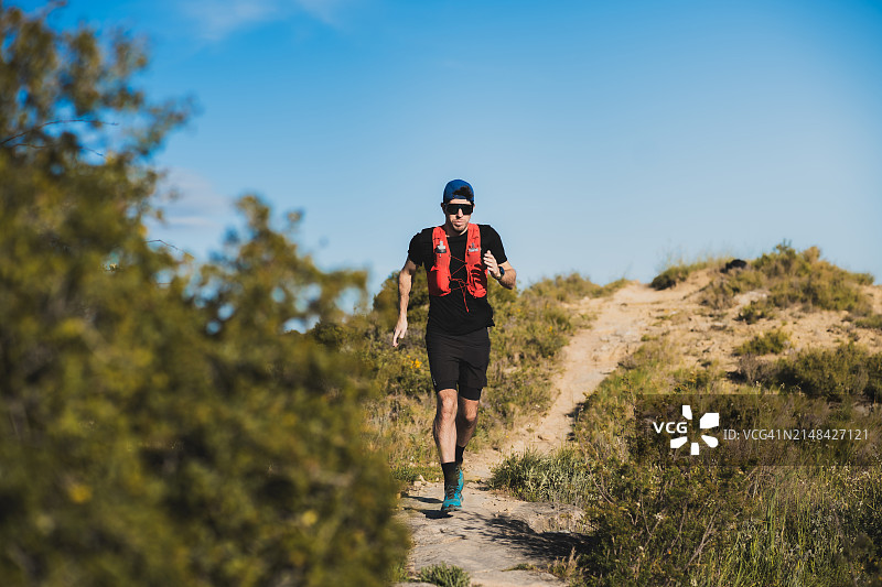 在茂盛的绿地中奔跑的孤独跑者图片素材