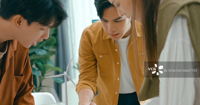 团队成员检查ESG相关文件特写，讨论可持续和可再生能源的投资策略，讨论ESG目标的环保企业图片素材