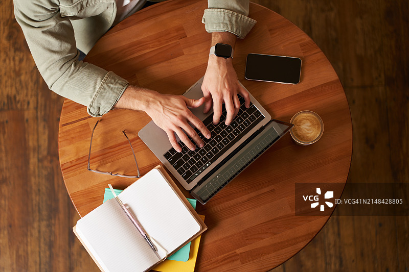 商人在桌子上使用笔记本电脑的高角度景观图片素材