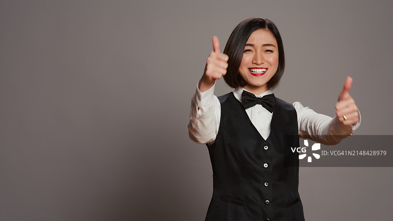 笑容满面的年轻女子在灰色背景下手势图片素材