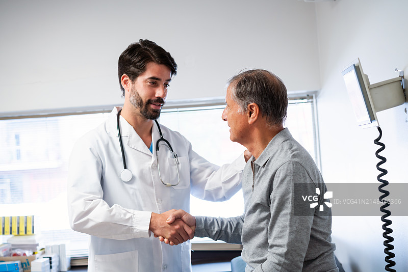 在诊所与病人握手的自信医生图片素材