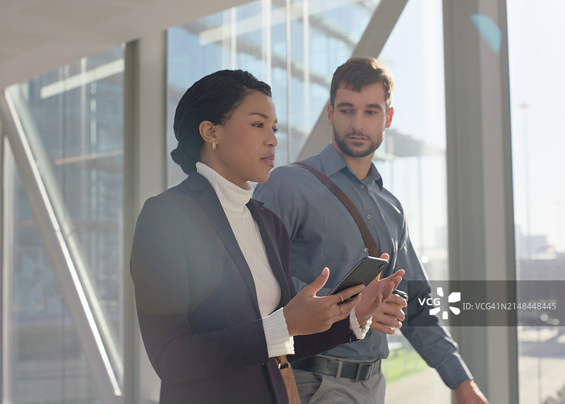 商务、同事和智能手机在办公室交谈，浏览互联网、网站和在线内容。员工、手机和讨论会议或工作计划和会议图片素材
