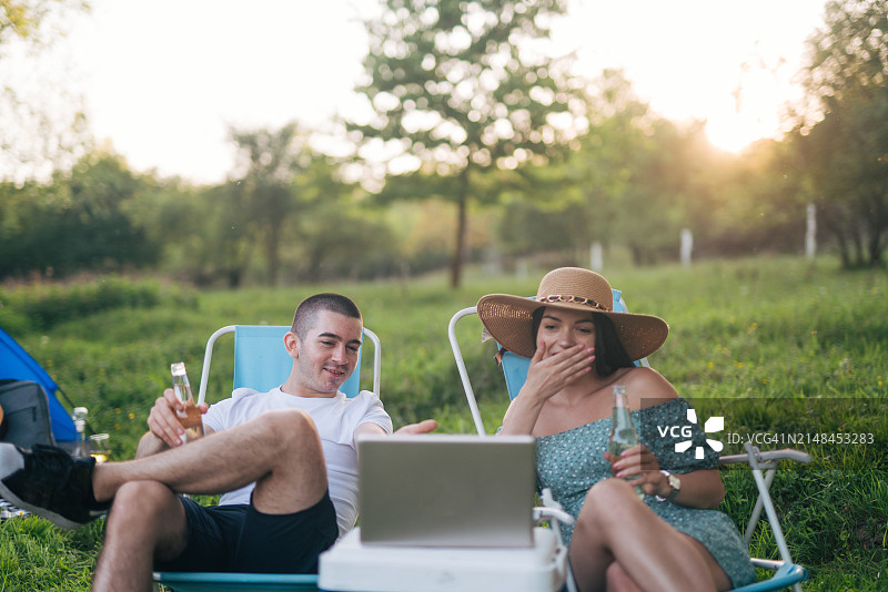 年轻夫妇在户外用笔记本电脑看电影图片素材