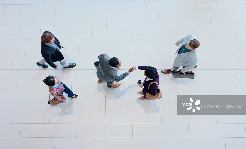 俯视角度：商务人士握手达成交易，欢迎来到办公室，咨询顾问的团队合作和B2B协作图片素材