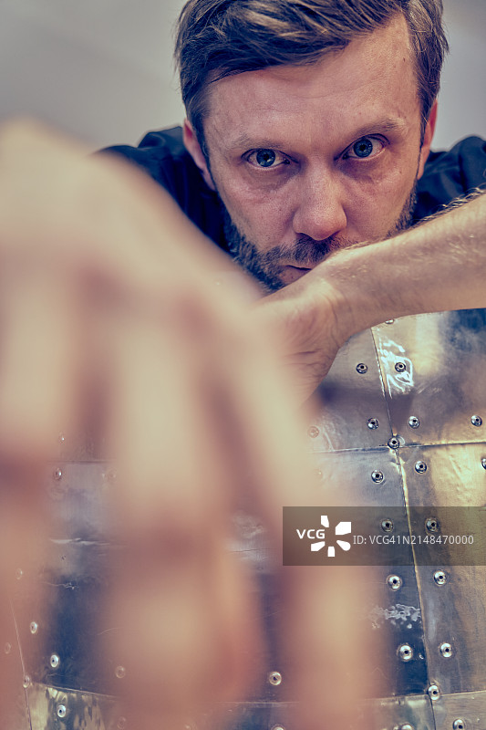 英俊的络腮胡男子特写肖像，张开双臂坐在飞行员蛋椅上图片素材