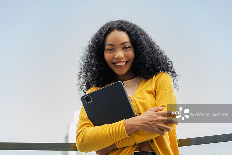 年轻的黑人自由职业女性在市中心使用平板工作打电话图片素材
