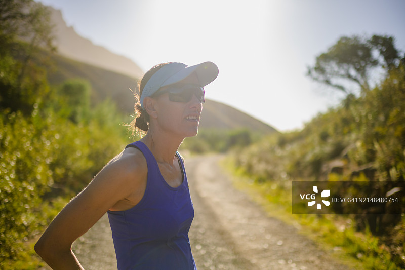 背光：准备在户外跑步的女子越野跑者，表情坚定图片素材