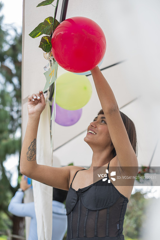 拉丁情侣用彩色炸弹装饰他们在酒店为朋友举办的惊喜派对图片素材