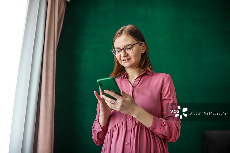 戴眼镜的女人正在看智能手机屏幕图片素材