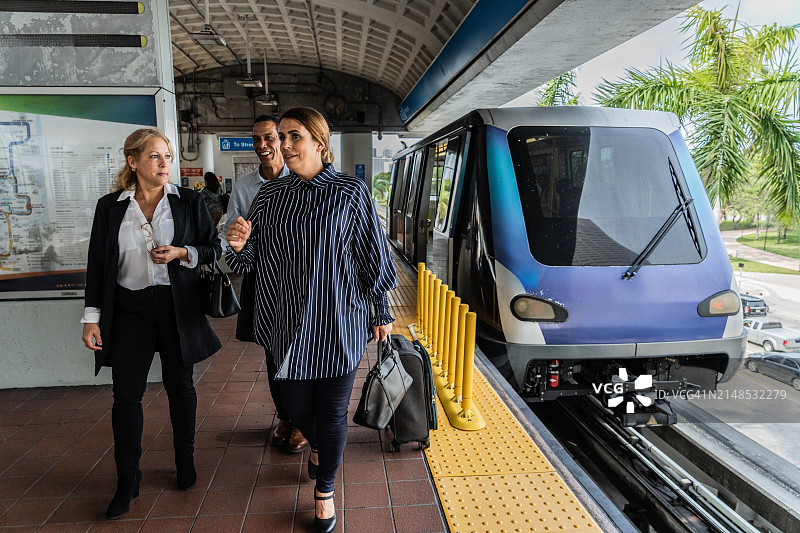 在地铁站交谈和行走的商务同事图片素材