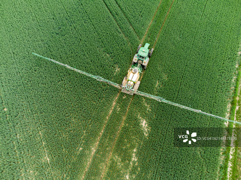 拖拉机向谷类作物喷洒农药的航拍图图片素材