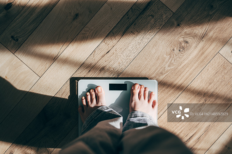 少女站在体重秤上测量体重图片素材