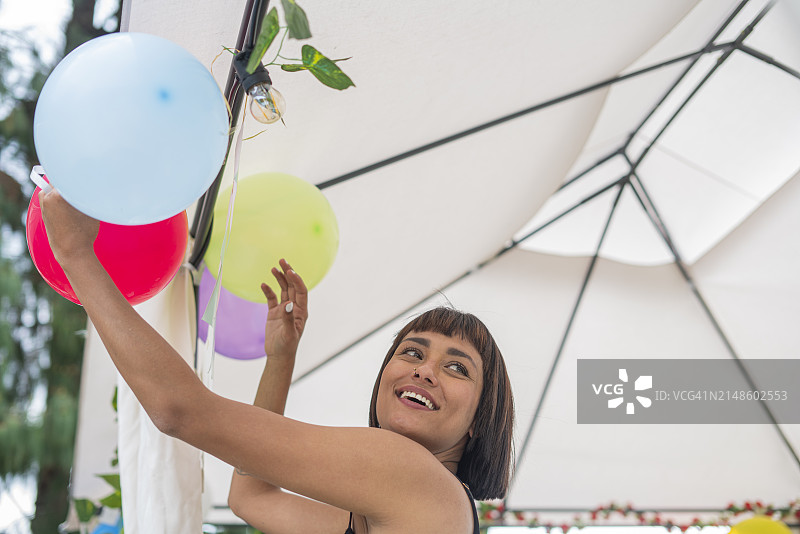 拉丁情侣用彩色炸弹装饰他们在酒店为朋友举办的惊喜派对图片素材