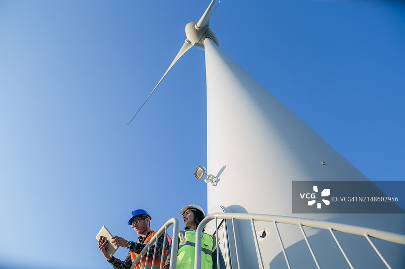 工程师在风力发电场维护风力涡轮机图片素材