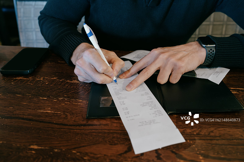 男人在餐厅信用卡账单上留下小费图片素材