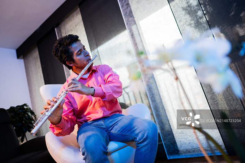 中年男人在家中吹笛子图片素材