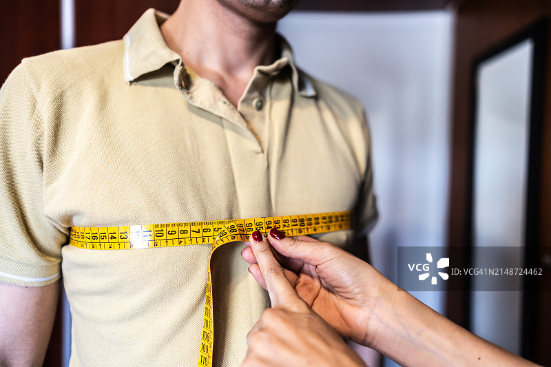 女人在办公室用卷尺为病人测量图片素材