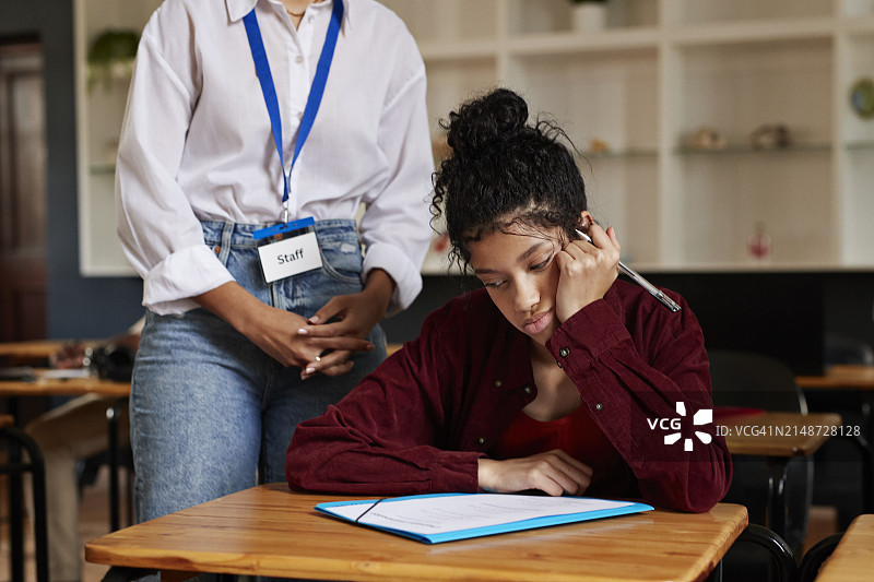 老师在考试期间站在女学生旁边图片素材