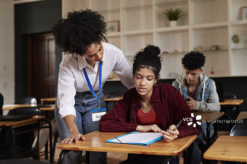 老师在考试中辅导女学生图片素材