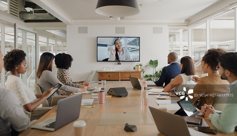 商务人士参加网络研讨会，与员工在会议上进行团队协作。员工在车间观看电视上的视频会议，进行董事会演示图片素材